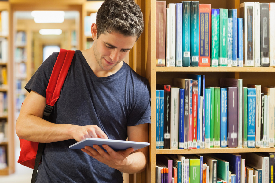 Jovem na biblioteca que faz parte da infraestrutura do curso de medicina