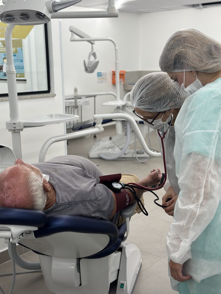 Aluno do curso de Odontologia da FCM-MG em atendimento real com paciente, vivenciando na prática como é a formação clínica.